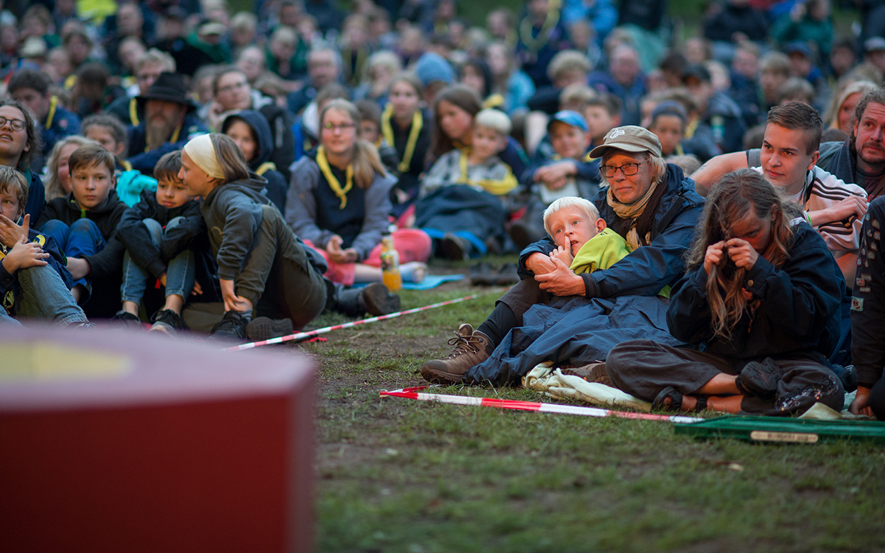 A group of scouts sitting around an opening campfire